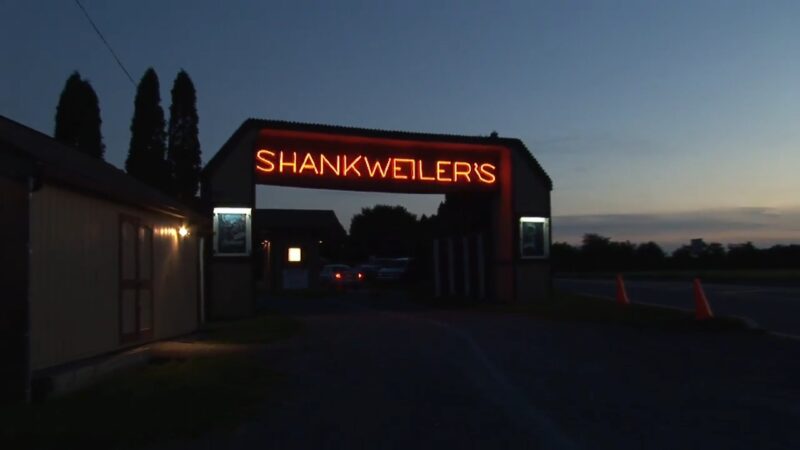 Shankweiler’s Drive-In entrance glows at dusk before the movie starts