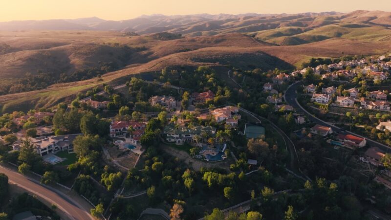 Aerial view of large luxury homes surrounded by rolling hills in Hidden Hills, California
