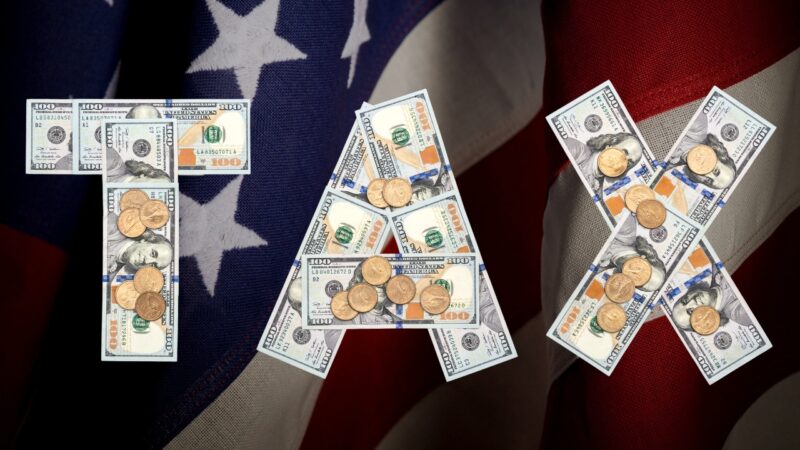 Tax symbols made with dollar bills and coins on a U.S. flag background