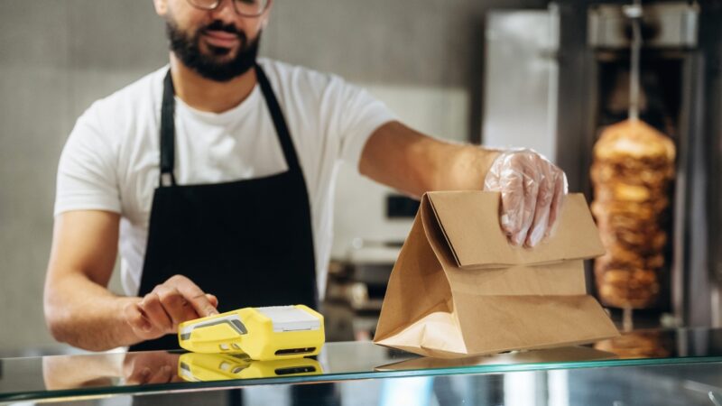 Fast food worker packing a takeaway order at a restaurant counter